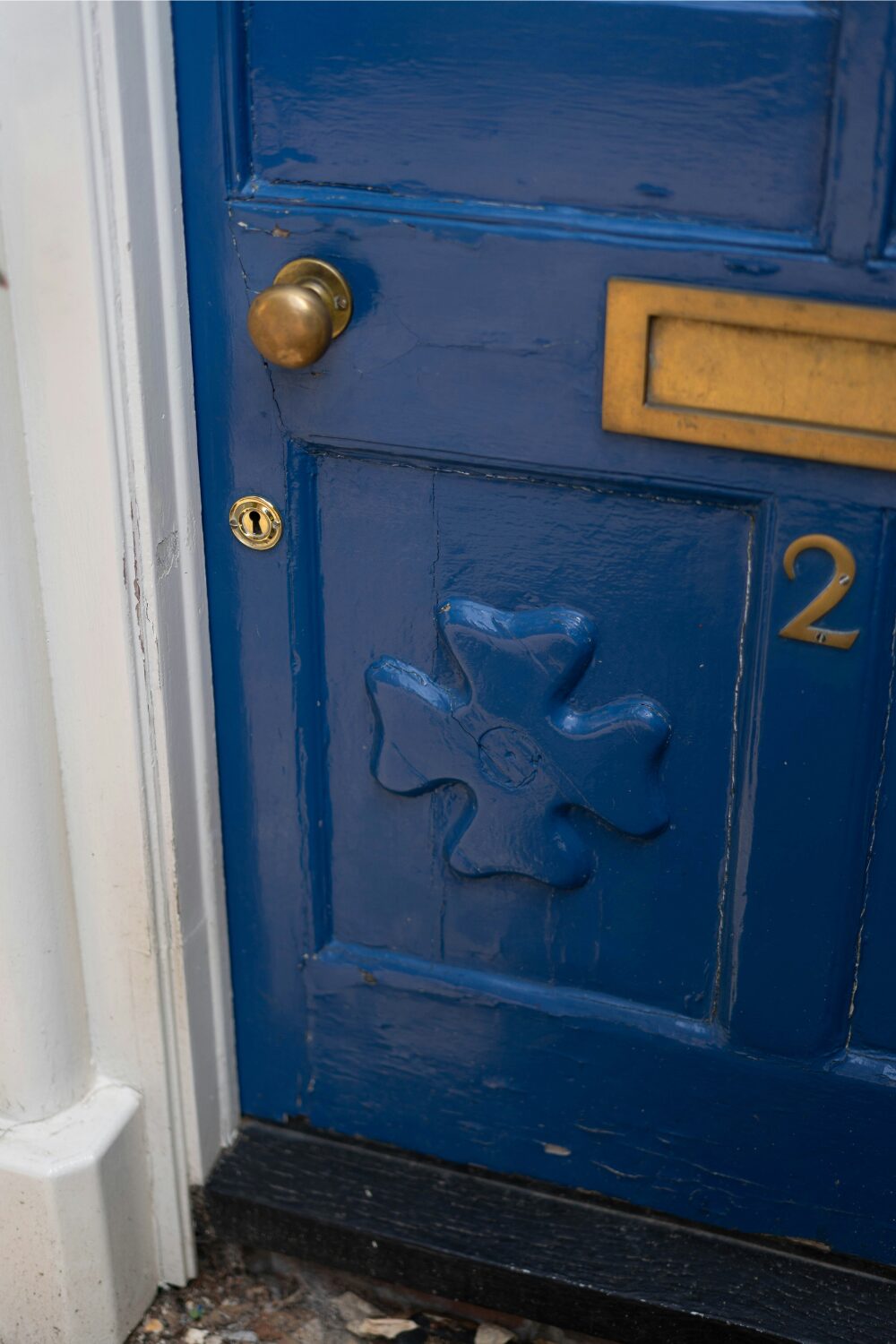 Blue front door with cross design, and gold handle and letterbox