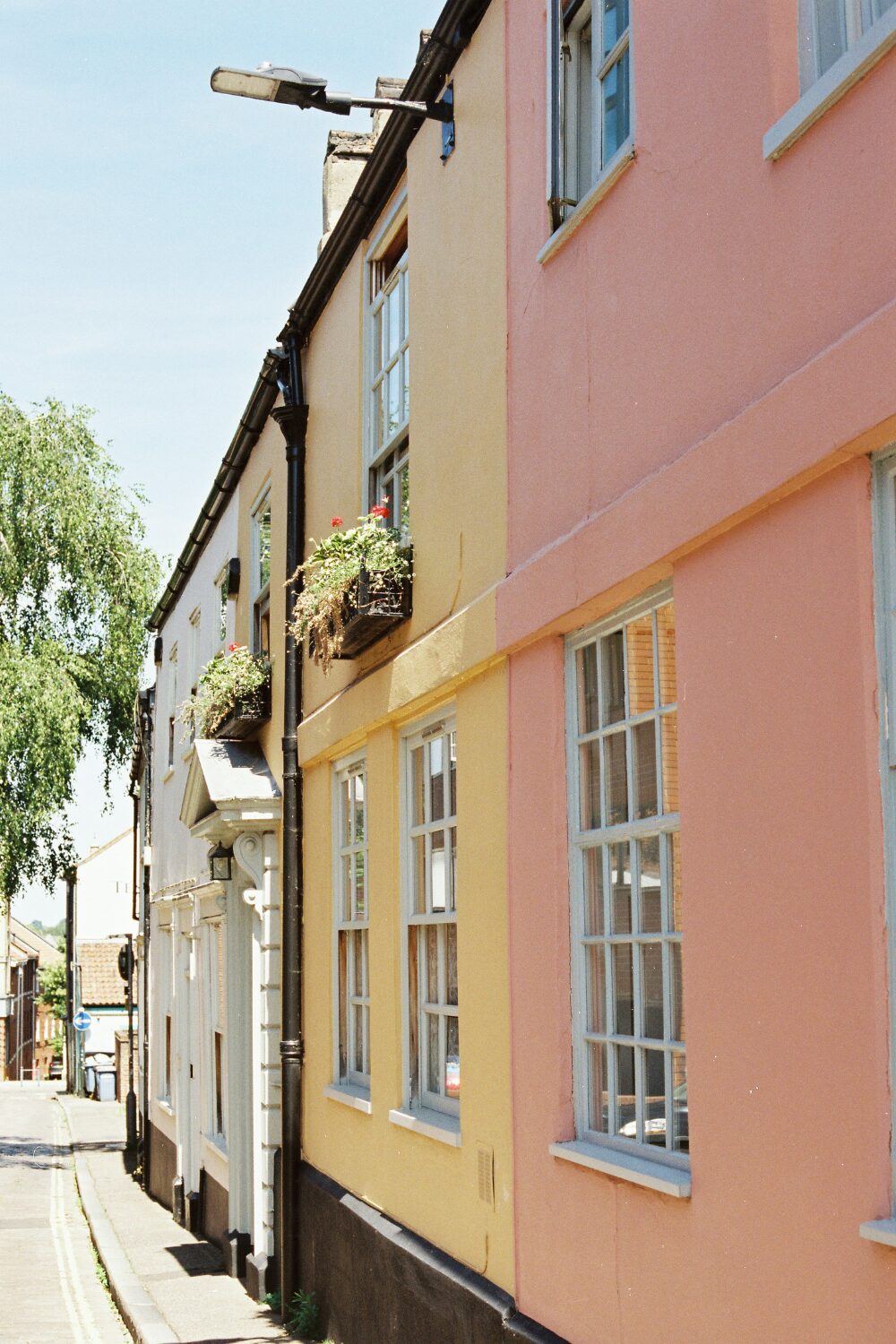 Row of terraced houses painted pink, white and yellow