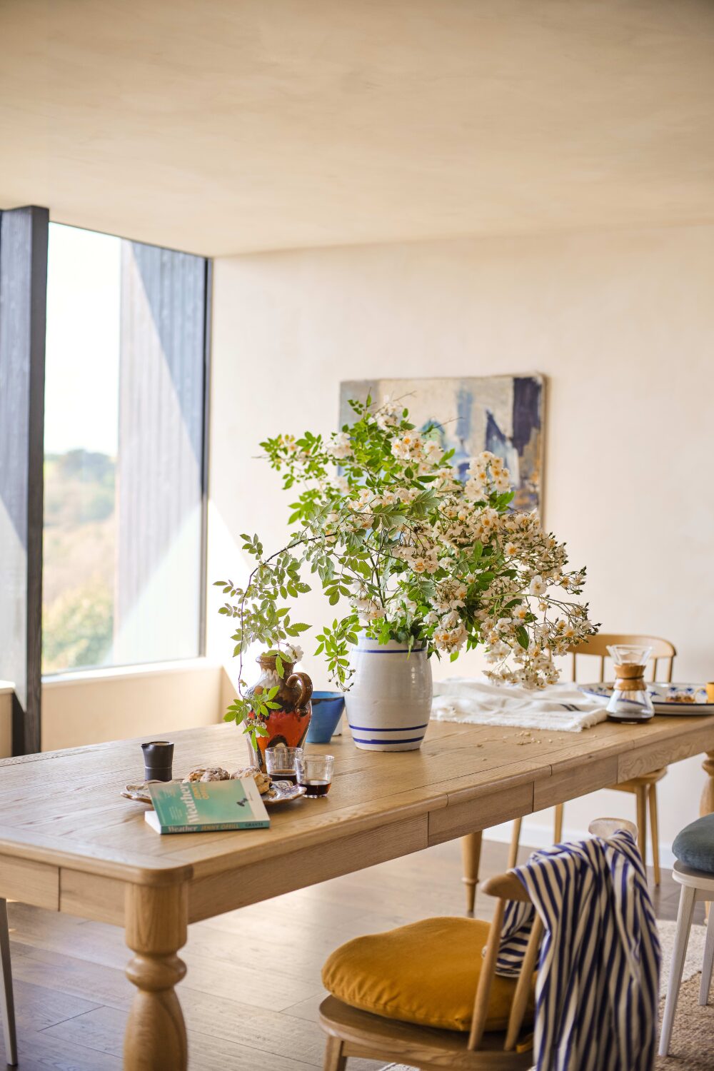 Wooden table in white kitchen with white vase holding flowers
