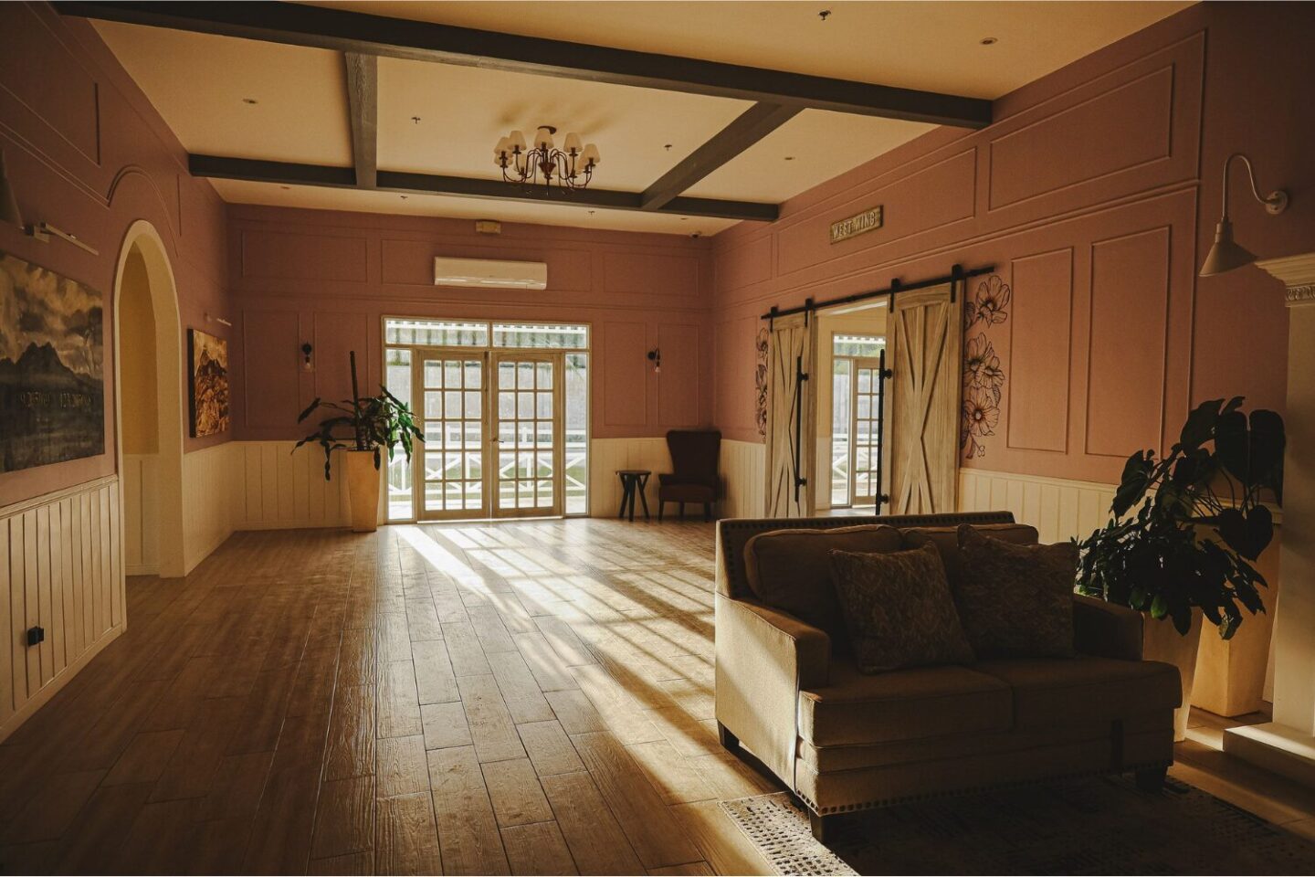 Large open room with wooden floor, stable doors and French windows