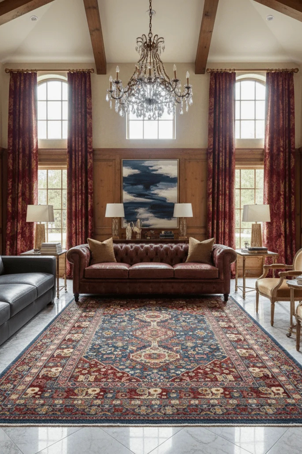 Wood-panelled living room with patterned rug, brown leather sofa, upholstered chairs, chandelier and fireplace