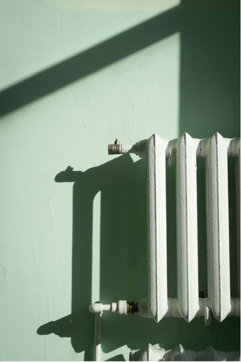 White radiator on a light green wall