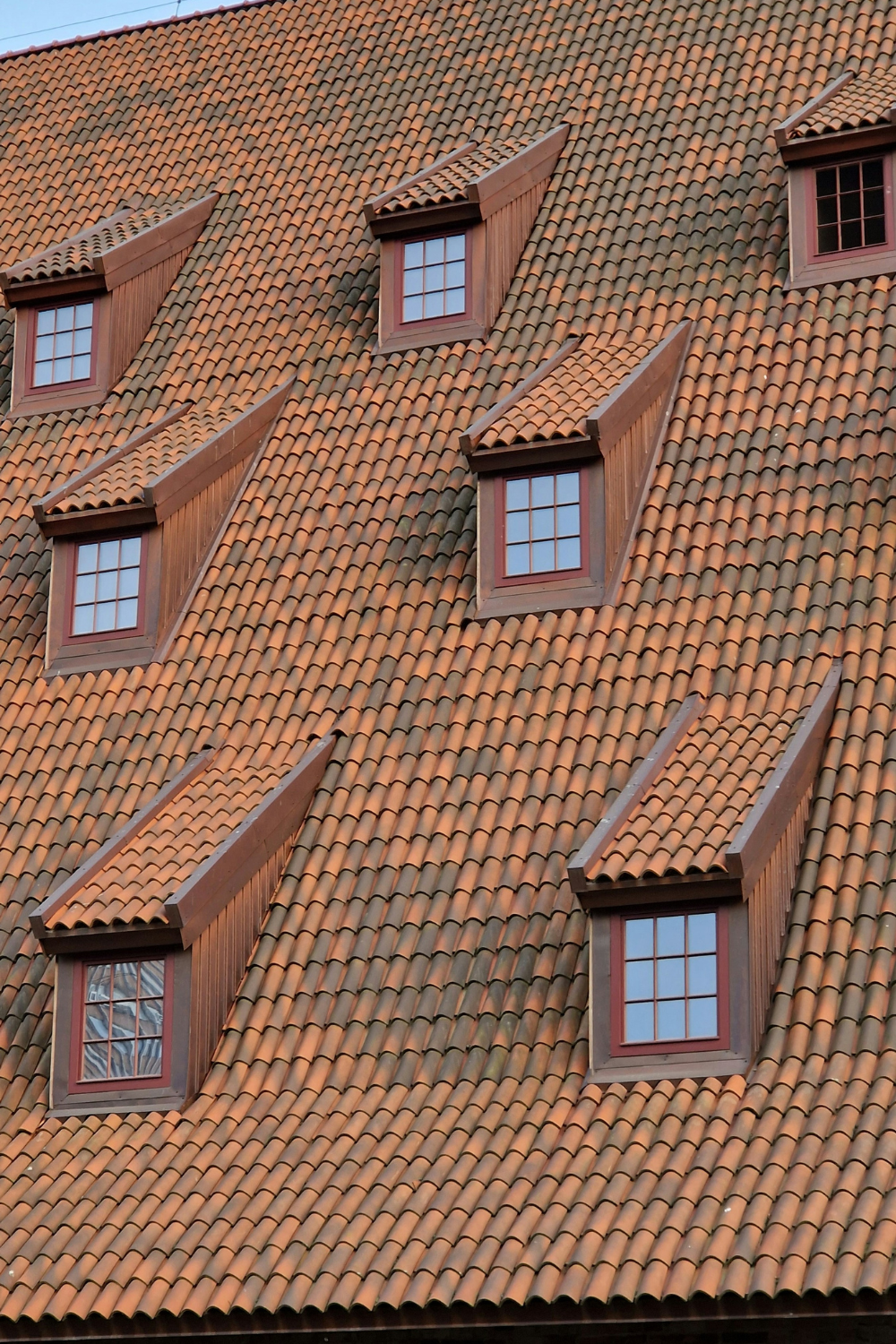 Red tile roof with rows of inset brown dormer windows