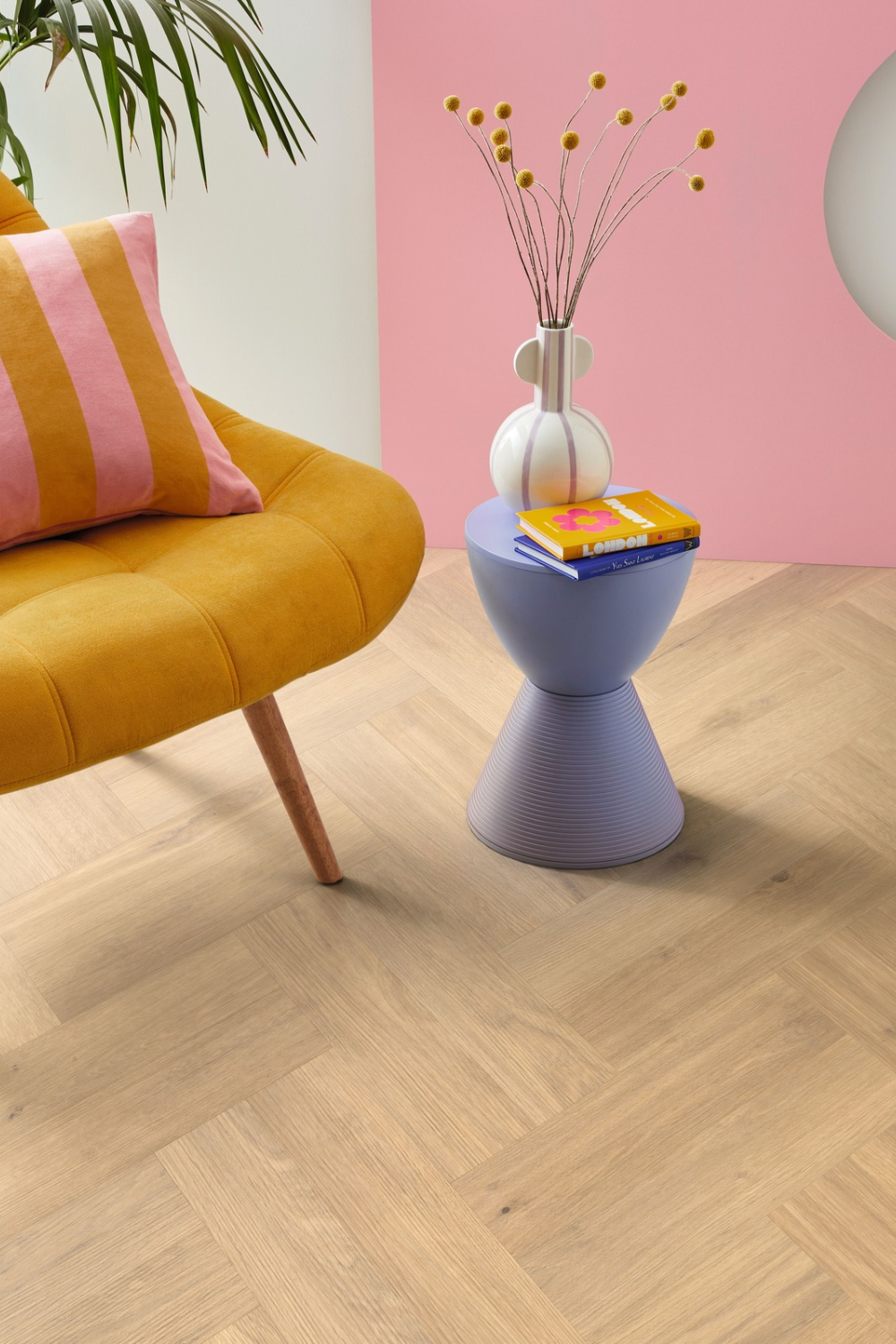 Orange sofa and blue side table in front of pink wall on wooden floor