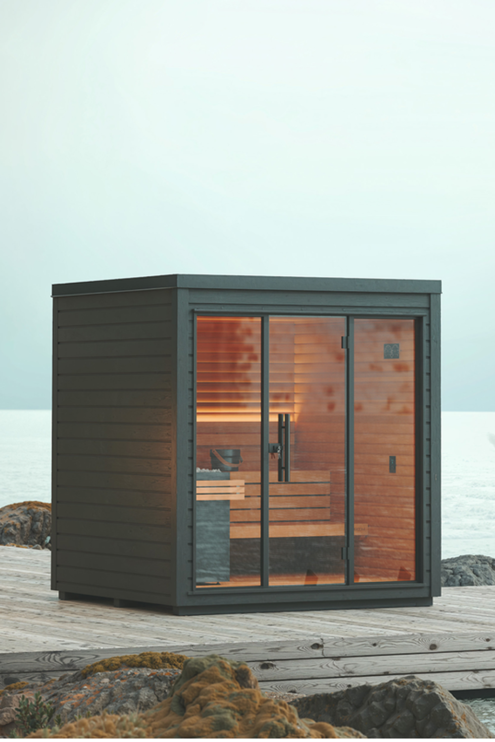 Black wood-lined sauna on wooden platform next to sea